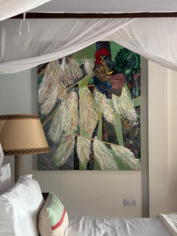 a bedroom with a bed with a painting on the wall at Gingerbread Suites in Port Elizabeth