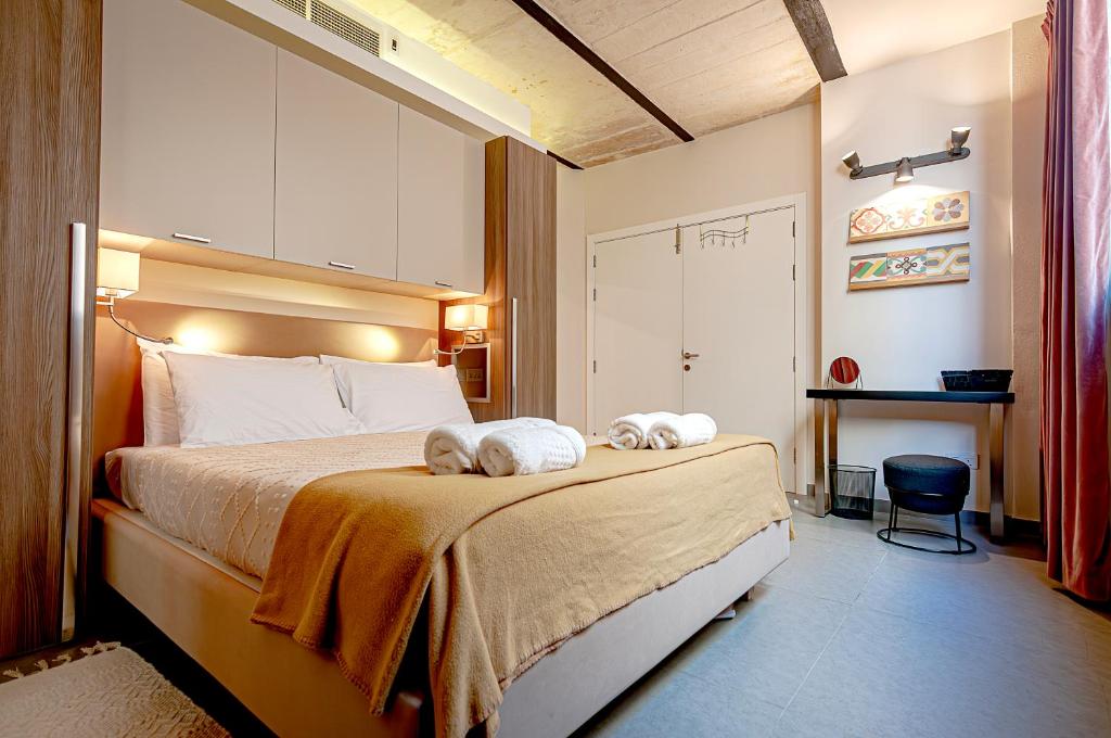 a bedroom with a bed with two towels on it at Valletta Collection Orangerie 401 in Valletta
