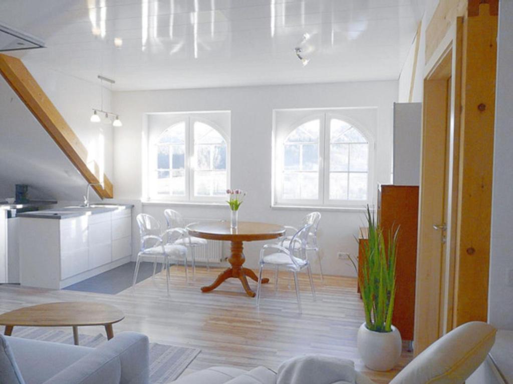 a living room with a table and a kitchen at Ferienwohnung "Monte Noble" Südpfalz in Erlenbach