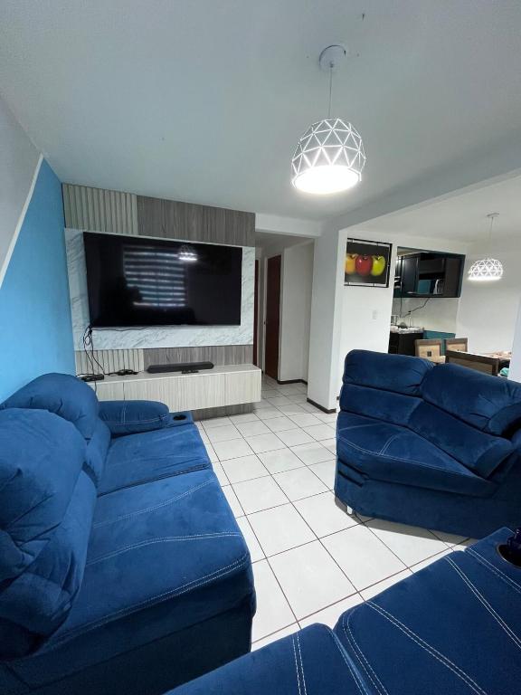 a living room with blue couches and a flat screen tv at Casa residencial Santa María in Oaxaca City