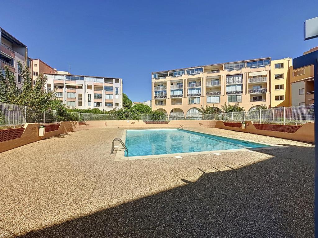a swimming pool in the middle of a building at T1 Familial avec Terrasse, Piscine, Plage à 6 Min à Pied et Aqualand à 2 Min in Cap d'Agde