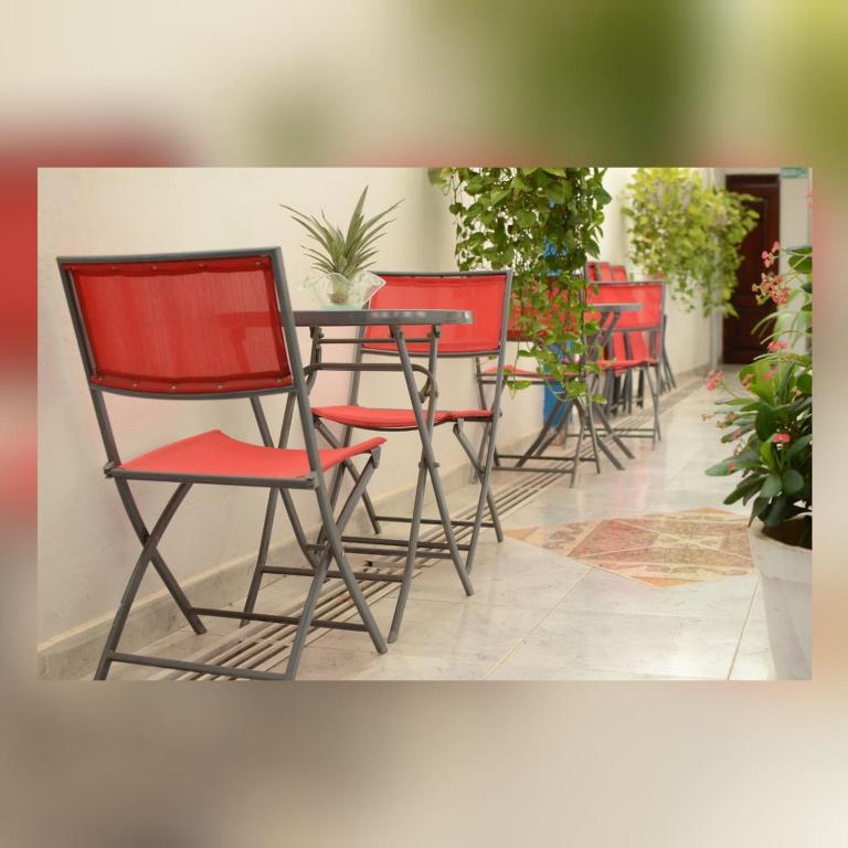 a group of red chairs sitting around a table at Hotel Isla Capri in Mompos