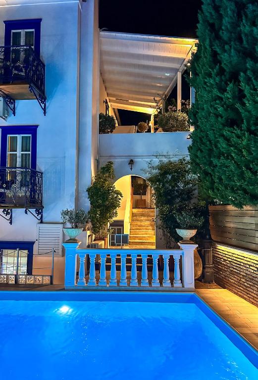 a house with a swimming pool in front of a building at Armata Boutique Hotel in Spetses