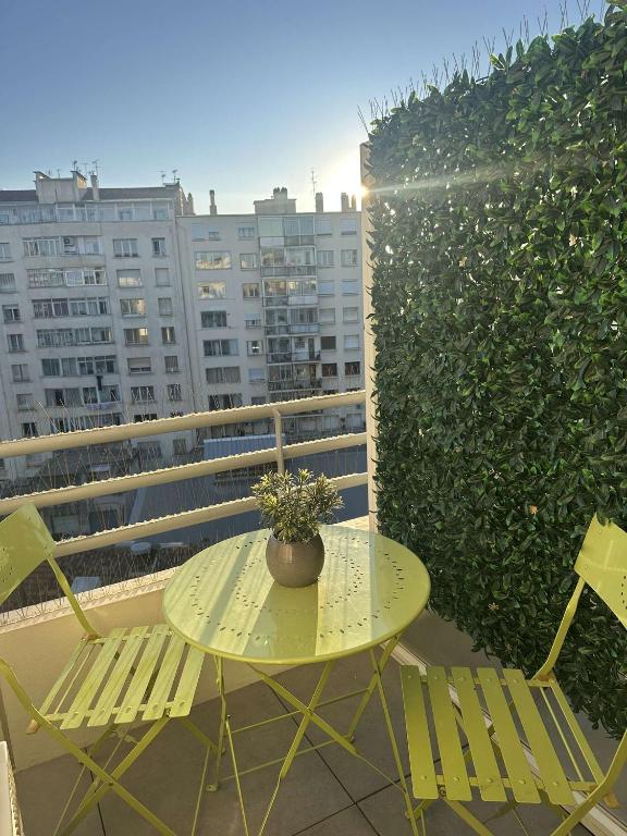 une table et des chaises sur un balcon avec une plante dans l'établissement T2 Castellane proche du stade vélodrome et du vieux port, à Marseille