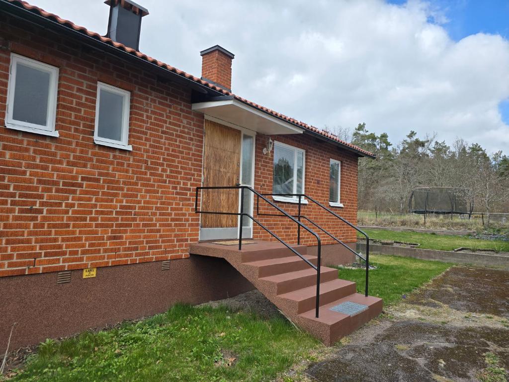 a brick house with a staircase in front of it at Blanka10 in Blankaholm