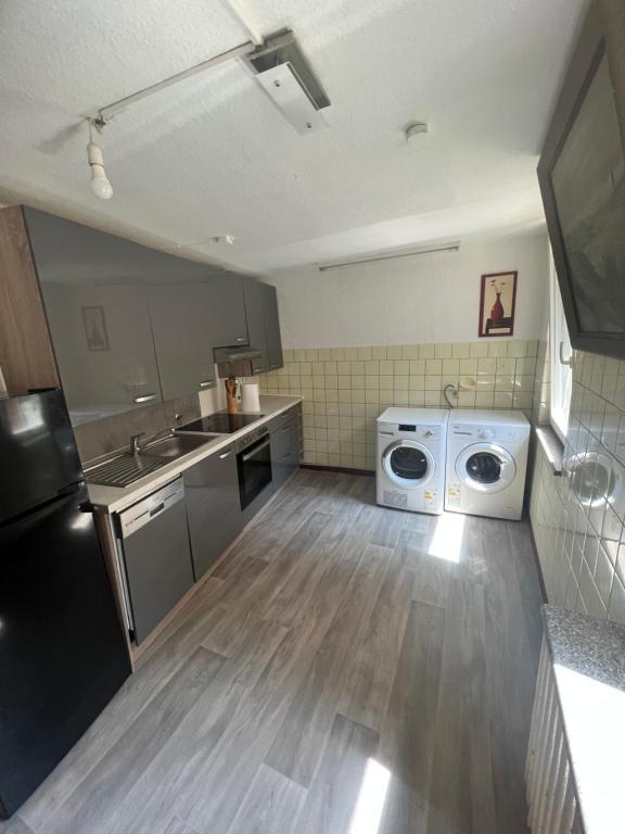 une cuisine avec un évier et une machine à laver dans l'établissement Cin Pension, à Gronau