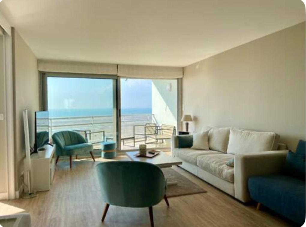 un salon avec un canapé et une vue sur l'océan dans l'établissement Le Front de mer - Centre-ville - Vue mer - Parking gratuit, à Le Touquet-Paris-Plage