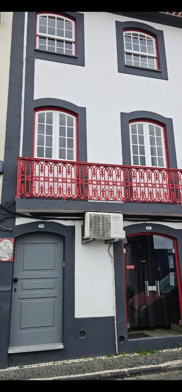 a white building with a red balcony on it at Sé House View in Angra do Heroísmo
