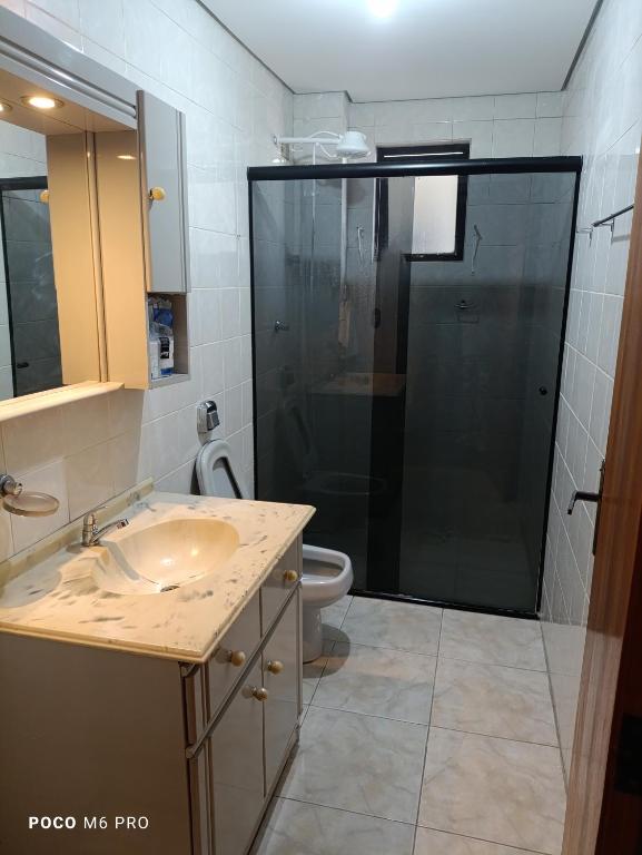 a bathroom with a shower and a sink and a toilet at Apartamento central in Uruguaiana