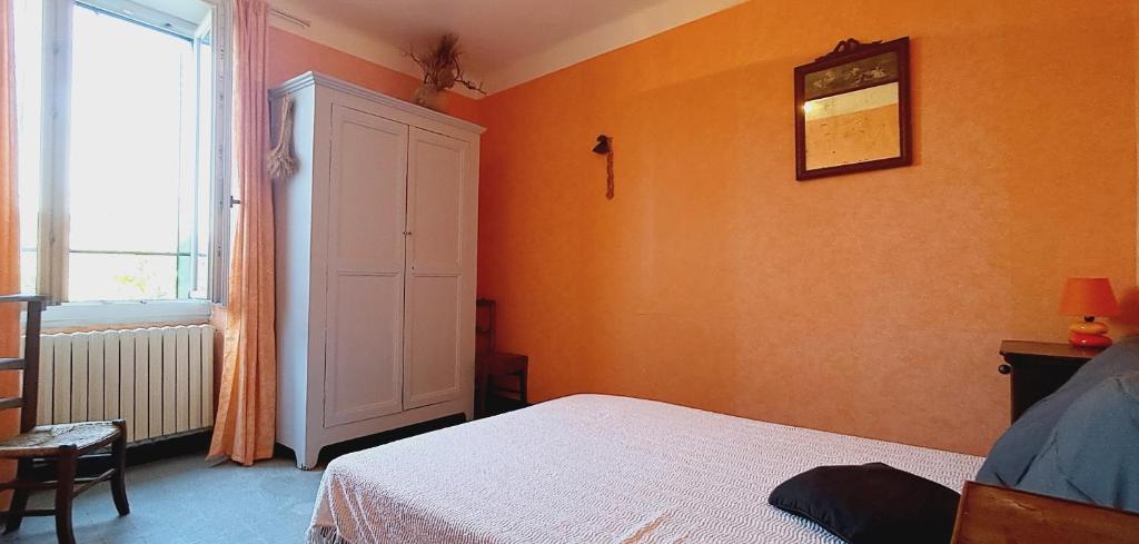 - une chambre avec des murs orange, un lit et une fenêtre dans l'établissement L'Andronne, à Vallon-Pont-dʼArc