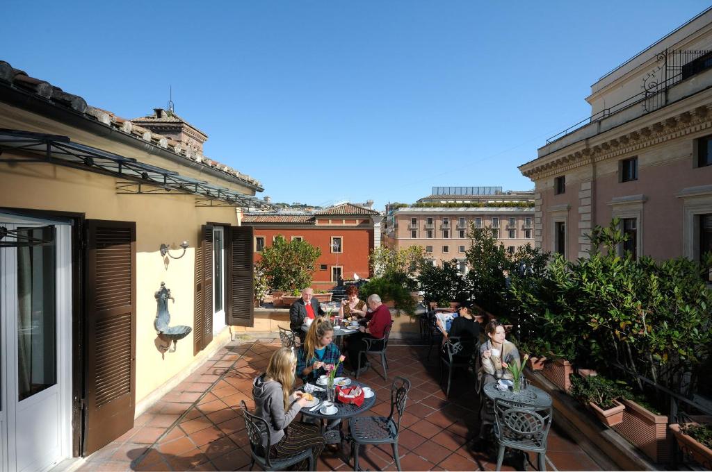 a group of people sitting at tables on a patio at Parlamento Boutique Hotel in Rome