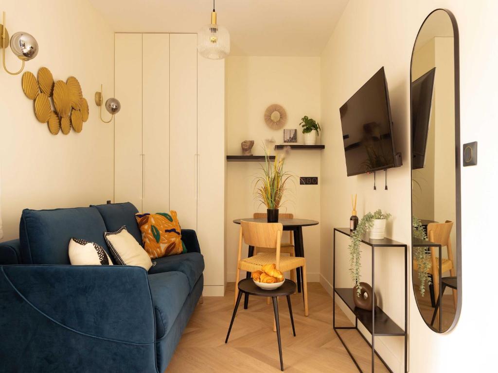 a living room with a blue couch and a mirror at Charming studio 2P- Montorgueil in Paris