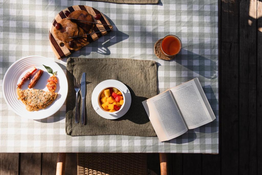 un tavolo con un piatto di cibo e un libro di Enkusero Mara ad Aitong