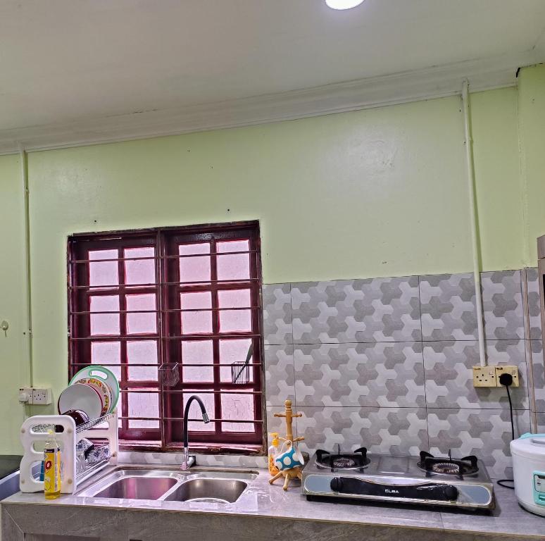 a kitchen counter with a sink and a window at Raniah Homestay 2 in Gua Sai