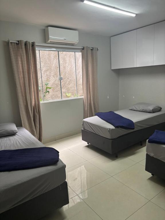 a bedroom with two beds and a window at Pousada Campinas in Campinas