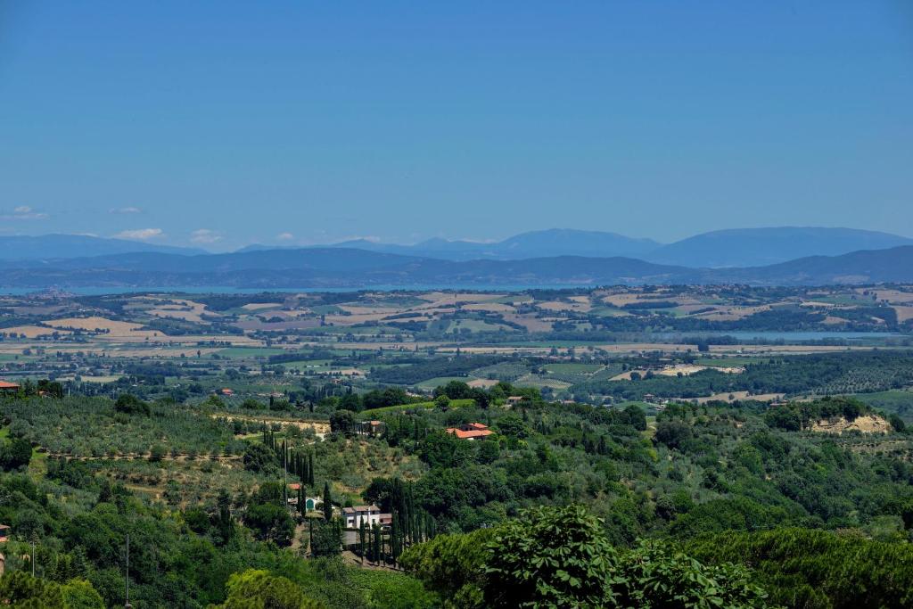 a view of a valley with trees and mountains at La Corte Medicea in Montepulciano