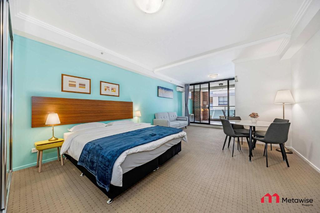 シドニーにあるMetaWiseBnB Studio Dixon Next to ICC & Darling Harbour 23のベッドルーム1室(大型ベッド1台、テーブル、椅子付)
