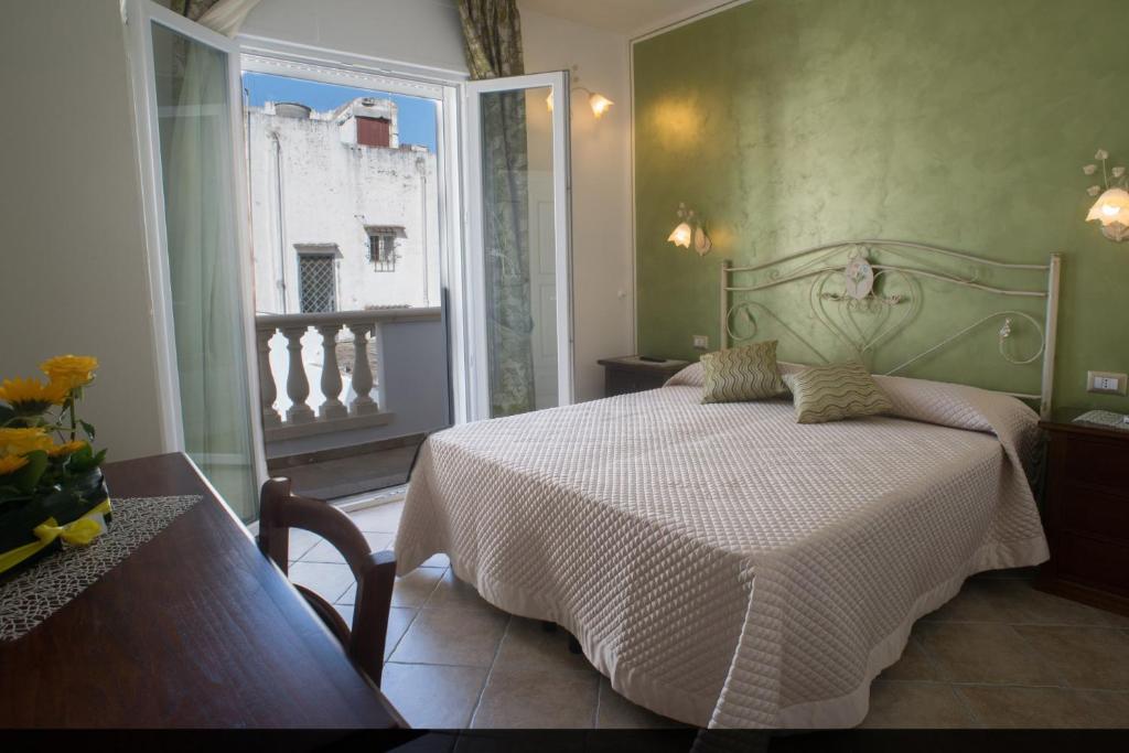 a bedroom with a white bed and a window at B&B Corte dell' Immacolata in Taviano