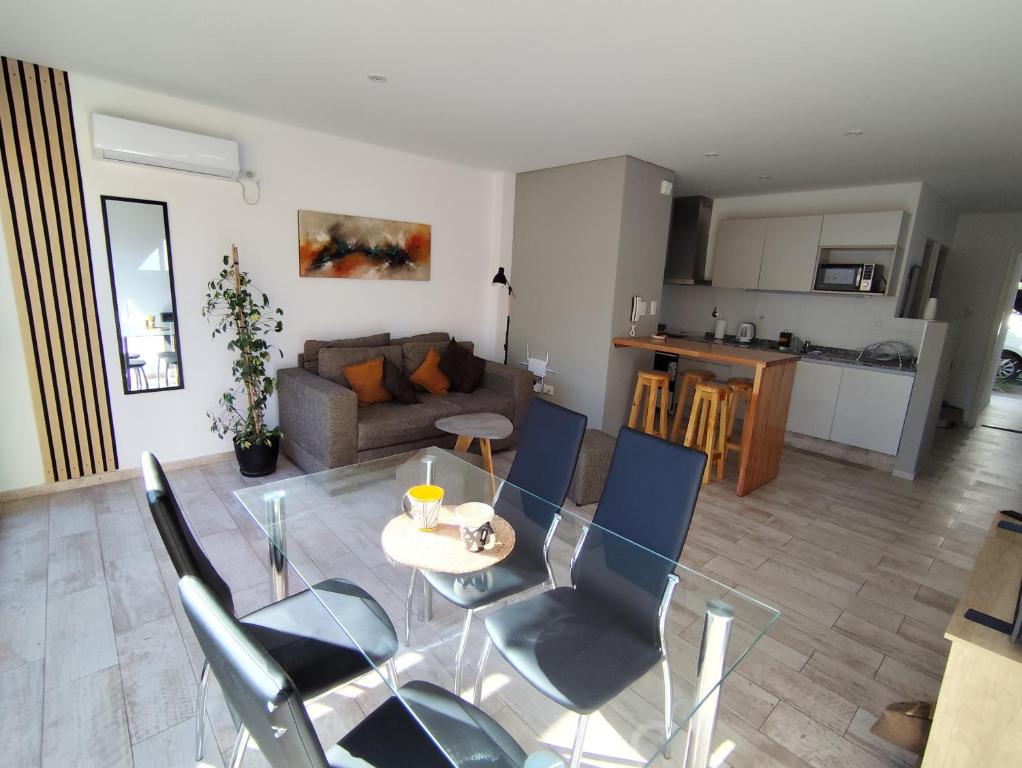 a living room with a glass table and chairs at San Vicente in Godoy Cruz