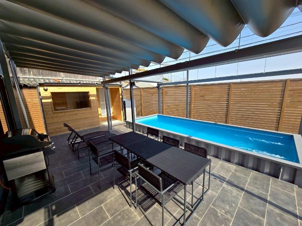 a patio with a swimming pool and a table and chairs at Tiz RESERVE EJIRI in Minamiawaji