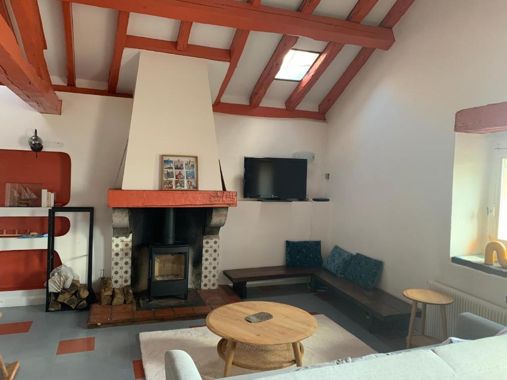 un salon avec une cheminée et une table dans l'établissement Appartement Espelette, à La Celle-sous-Gouzon