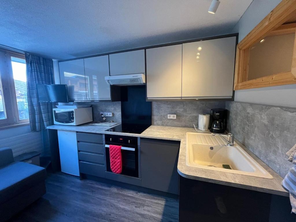 une cuisine avec un évier et un plan de travail dans l'établissement Studio le Palafour, ski-in ski-out, à Tignes