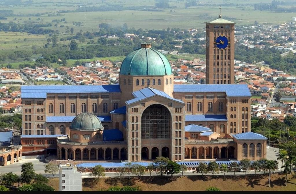 un grande edificio con una torre dell'orologio sopra di Casa em Aparecida próx a Basílica de Nossa Senhora a Aparecida
