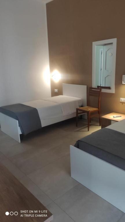 a bedroom with two beds and a table and a chair at Affittacamere Li Manca in Surbo