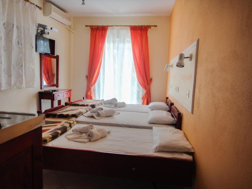 a group of beds in a room with a window at Studios Elena in Limenaria