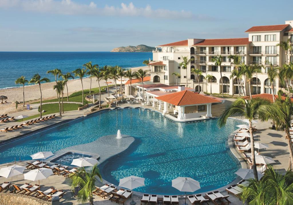 an aerial view of a resort with a swimming pool and the ocean at Dreams Los Cabos Suites Golf Resort & Spa in Cabo San Lucas