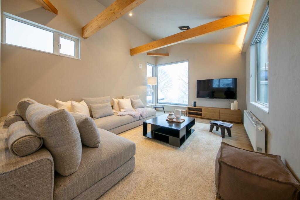 a living room with a couch and a tv at Chihiro Niseko in Kutchan