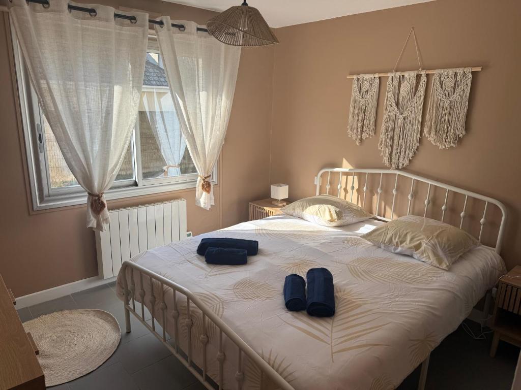 メルリモン・プラージュにあるSUNLIGHT Merlimont Appartement Plage Merlimont 10 mn Berck le Touquetのベッドルーム1室(ベッド1台、ブルースリッパ2枚付)