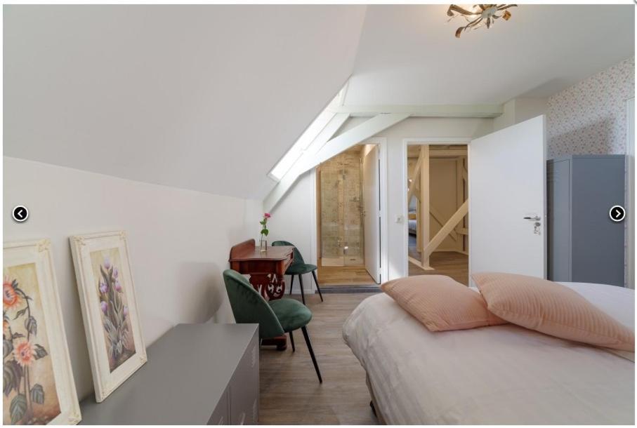 a bedroom with a bed and a desk in a room at Herberg de Griffioen in Wolphaartsdijk