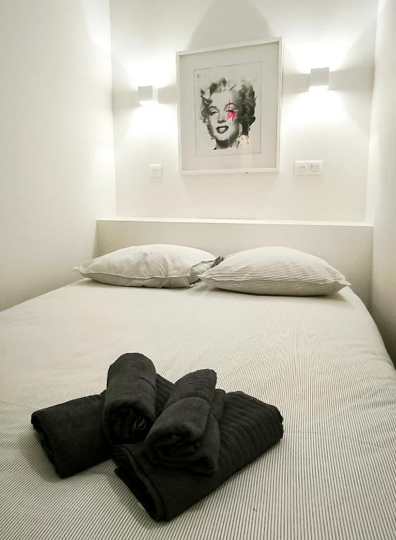 - un lit avec serviettes et 2 oreillers dans l'établissement Le Solari - Studio lumineux au cœur du centre historique, à Aix-en-Provence