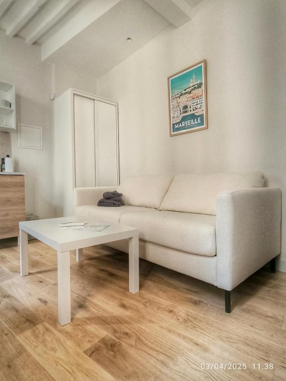 un salon avec un canapé blanc et une table dans l'établissement Le Mistral Studio au cœur du centre historique, à Aix-en-Provence