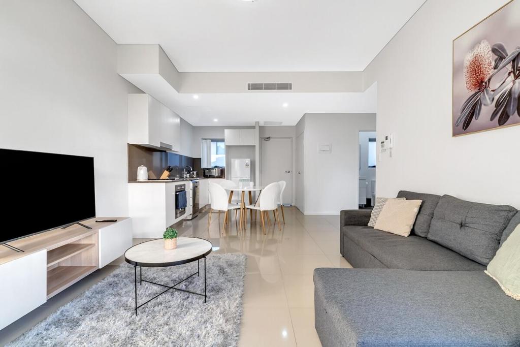 een woonkamer met een bank en een tv bij 41B Modern 1 Bedroom Abnb-Style apartment Free Parking in Bankstown