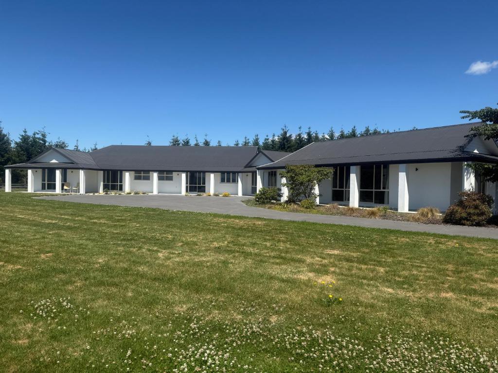 a house with a green lawn in front of it at Ruataniwha Lodge in Twizel