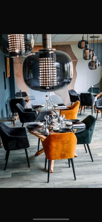 a group of tables and chairs in a restaurant at Logis Hotel-restaurant Les Glycines in Arles-sur-Tech