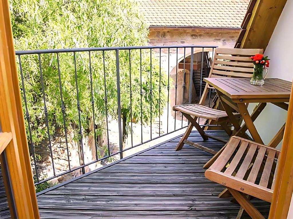 Una terraza de madera con una mesa y sillas en un balcón. en Auszeit beim Winzer- FeWo Idig, en Neustadt an der Weinstraße