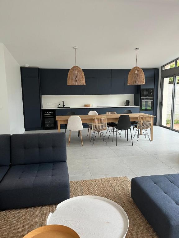 un salon avec un canapé bleu et une table dans l'établissement Magnifique villa à deux pas de la plage, à La Celle-sous-Gouzon