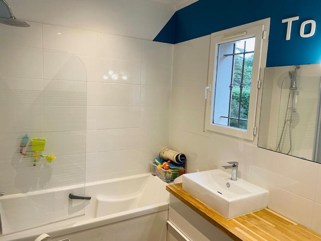 La salle de bains blanche est pourvue d'un lavabo et d'une baignoire. dans l'établissement Superbe villa provençale, à Ventabren