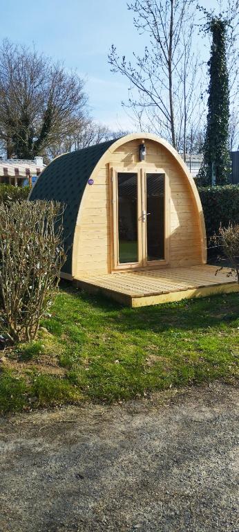 une petite cabane en bois avec une porte dans l'herbe dans l'établissement Pod, à Camoël