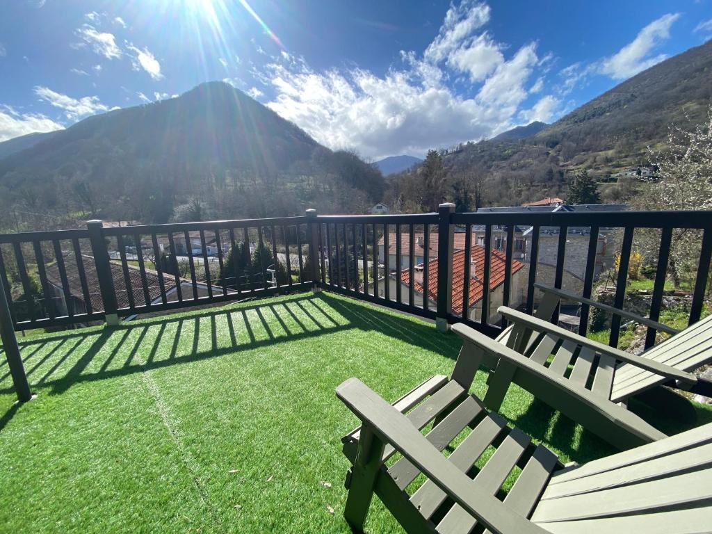 a balcony with two chairs and a view of a mountain at L'Antre II : Maison cosy / Ambiance chalet. in Mauléon-Barousse