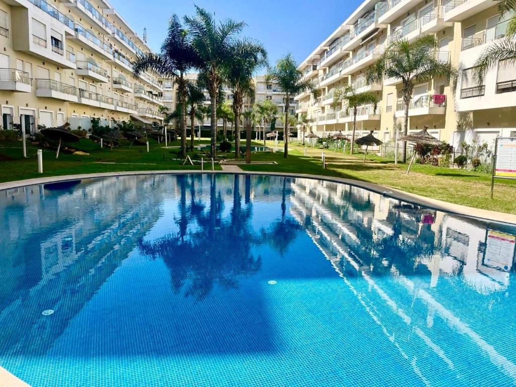 une grande piscine devant un immeuble dans l'établissement Les Jardins de Bouznika Premium - Votre espace familial, à Bouznika