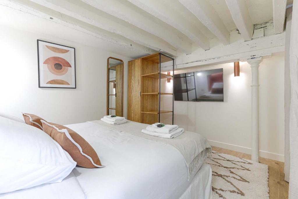 - une chambre blanche avec un lit blanc et un miroir dans l'établissement Residence - Roquette - Marais, à Paris