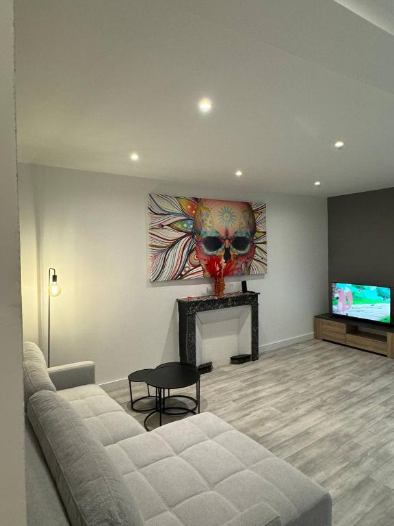 a living room with a couch and a television at le spacieux appart in Bourg-en-Bresse