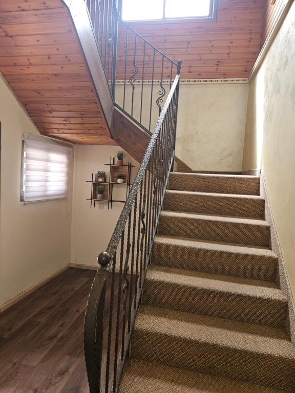 a staircase in a house with a wooden ceiling at דירת אירוח בצוריאל in Ẕuriʼel