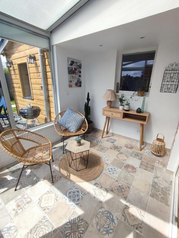 une terrasse couverte avec des chaises et une table. dans l'établissement Gîte à la campagne, à Fiquefleur-Équainville
