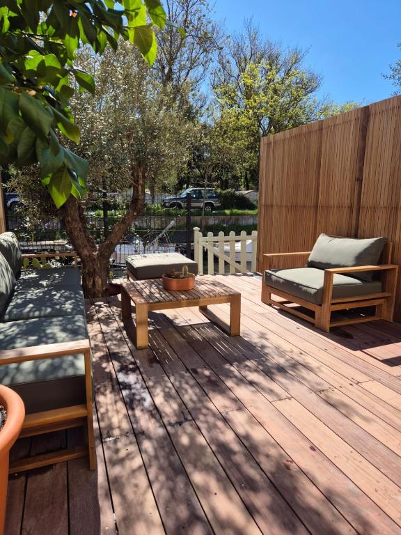 une terrasse en bois avec un banc et une table basse dans l'établissement LA MAISON DU PETIT PORT 8mn de St Tropez Entièrement rénovée en 2025, à Cogolin