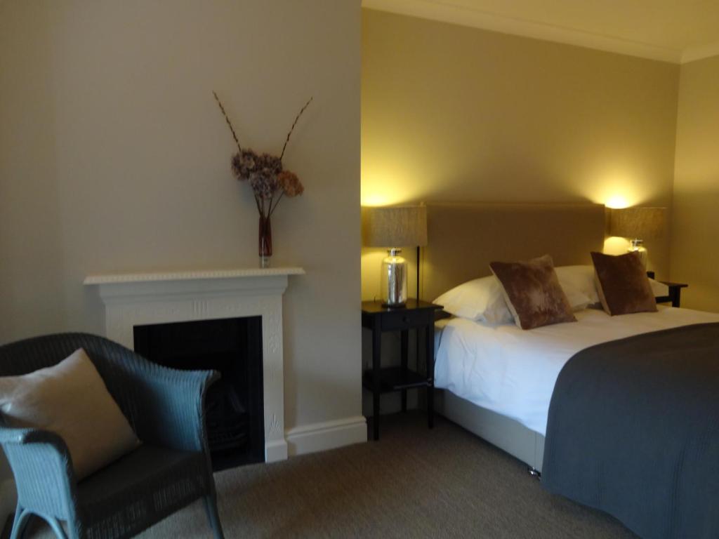 a hotel room with a bed and a fireplace at Ogilvy House in Cromer